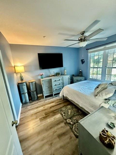 bedroom with baseboards, a ceiling fan, and wood finished floors