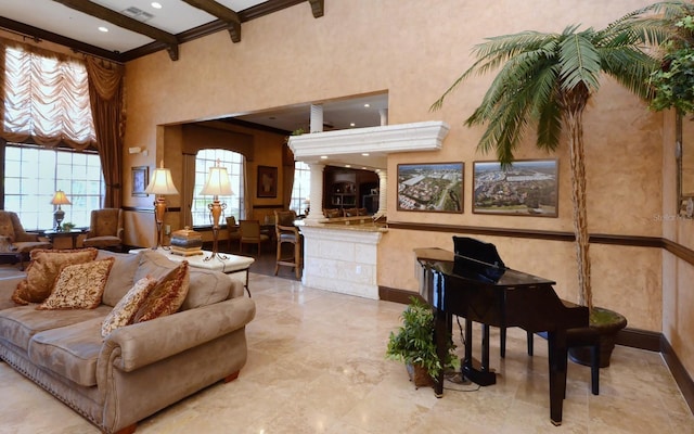 living area featuring beam ceiling, a towering ceiling, visible vents, and baseboards