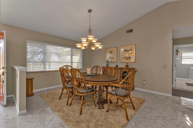 tiled dining room featuring lofted ceiling and a chandelier