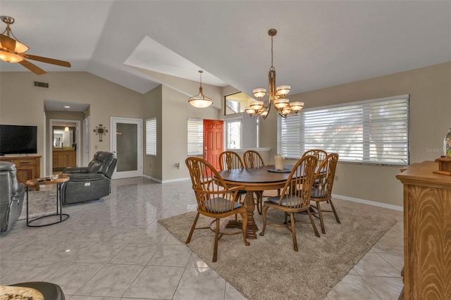 tiled dining area with a wealth of natural light, ceiling fan with notable chandelier, and lofted ceiling