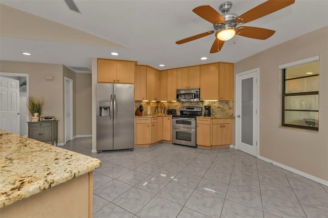 kitchen with light stone counters, light brown cabinets, light tile patterned floors, and stainless steel appliances