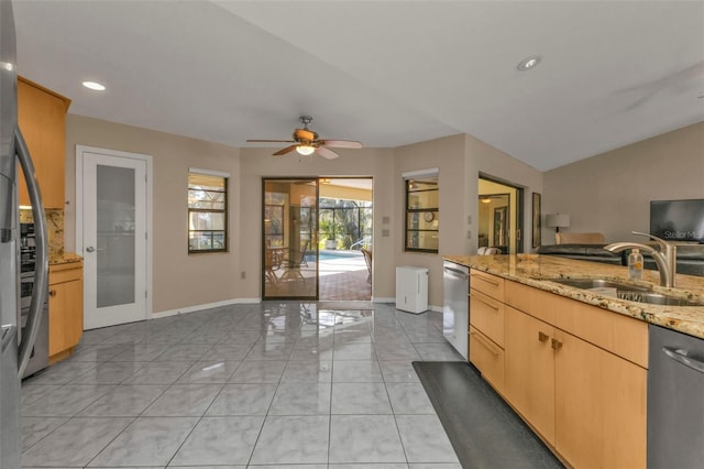 kitchen featuring light stone countertops, french doors, sink, light brown cabinetry, and appliances with stainless steel finishes