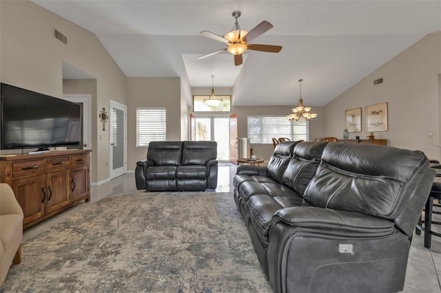 living room with lofted ceiling, light tile patterned floors, and ceiling fan with notable chandelier