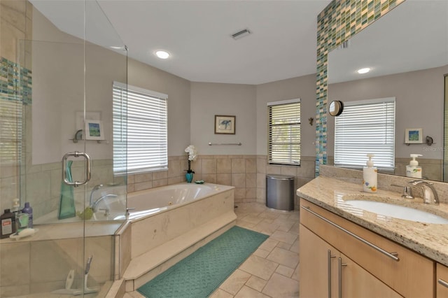 bathroom with separate shower and tub, plenty of natural light, vanity, and tile patterned flooring