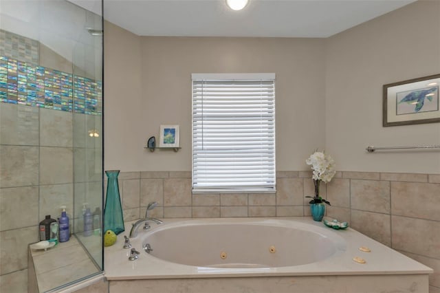 bathroom with tiled bath and a healthy amount of sunlight