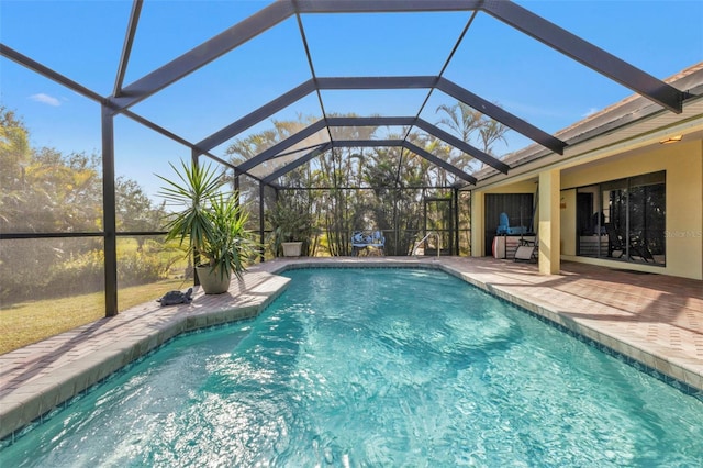 view of swimming pool featuring a patio area and glass enclosure