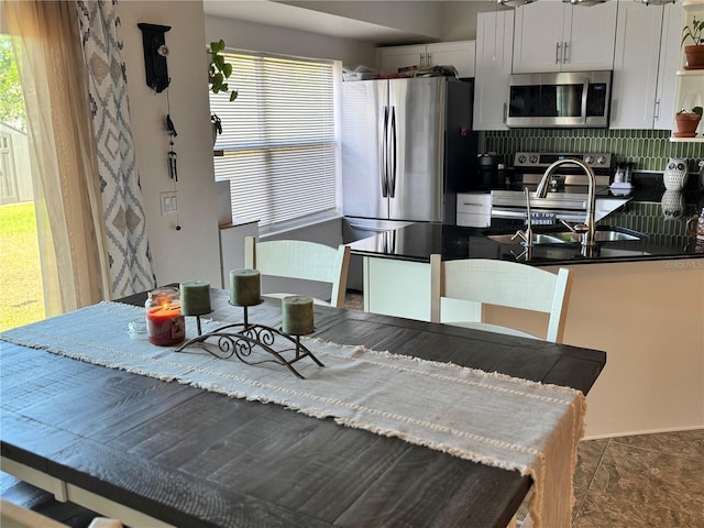 kitchen featuring white cabinets, appliances with stainless steel finishes, a wealth of natural light, and sink