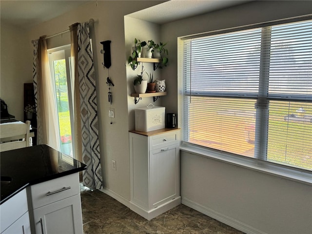 kitchen featuring plenty of natural light and white cabinetry