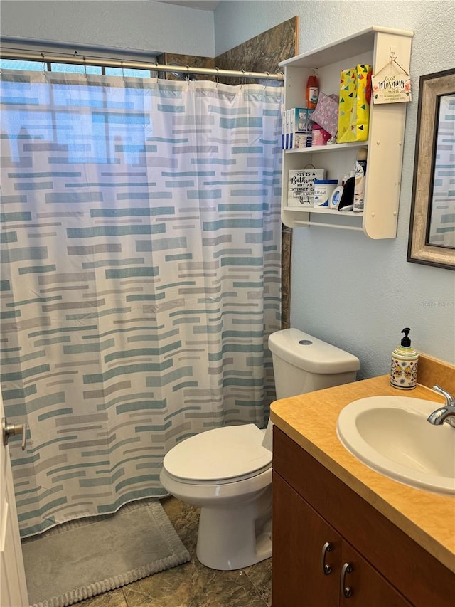 bathroom featuring a shower with curtain, vanity, and toilet