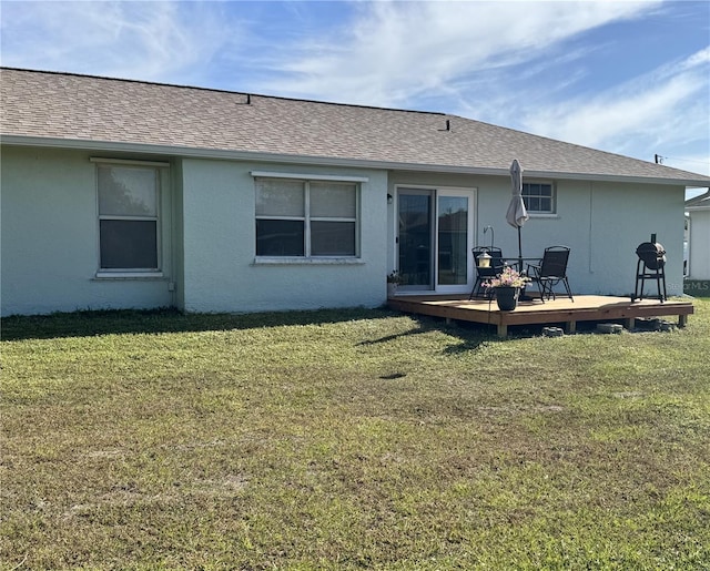 rear view of house featuring a lawn and a wooden deck