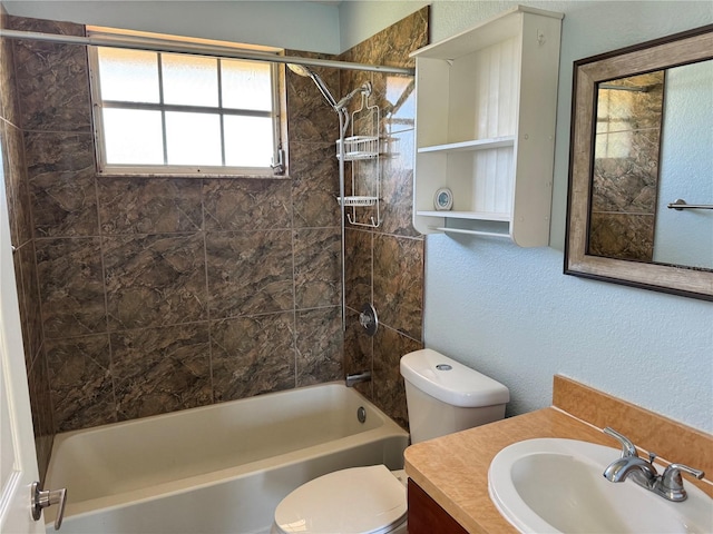 full bathroom with vanity, tiled shower / bath combo, and toilet