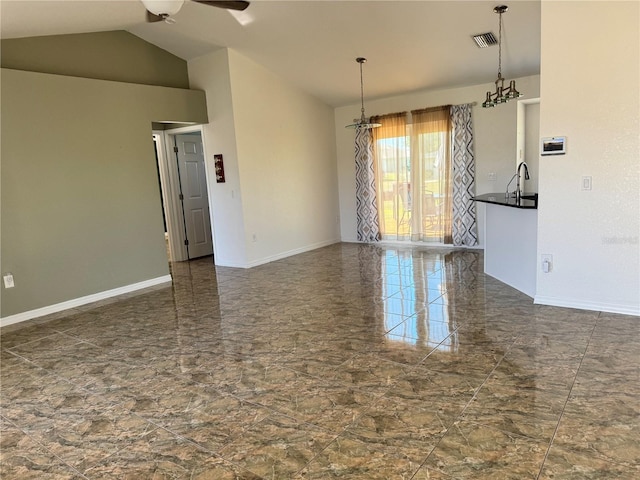 empty room featuring ceiling fan, sink, and vaulted ceiling