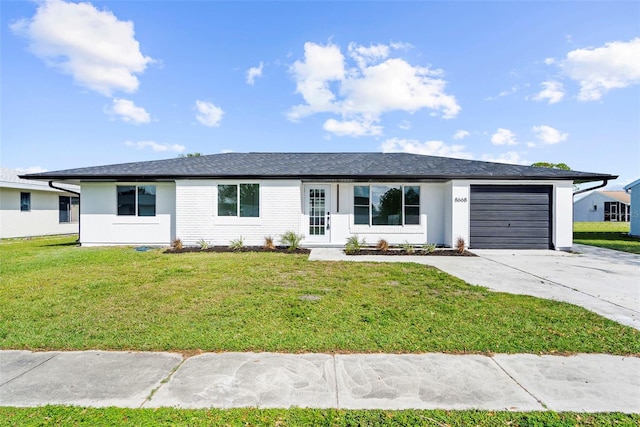 ranch-style home featuring a garage and a front lawn