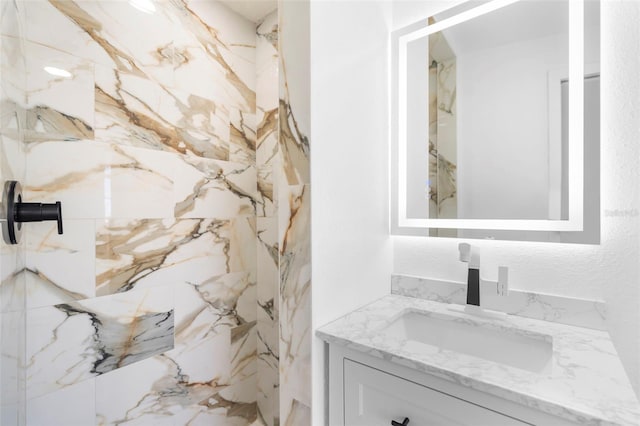 bathroom featuring a shower and vanity