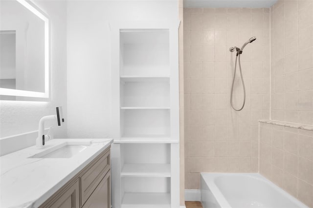 bathroom featuring vanity and tiled shower / bath