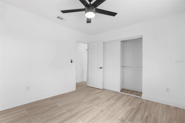 unfurnished bedroom with light hardwood / wood-style flooring, a closet, and ceiling fan