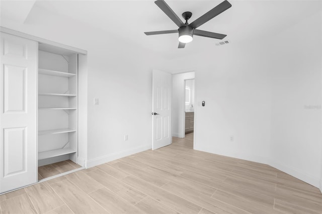 unfurnished bedroom with ceiling fan and a closet