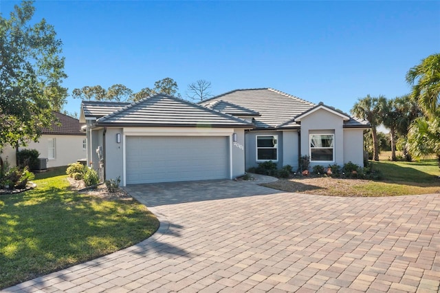 ranch-style house featuring a garage, a front yard, and central AC