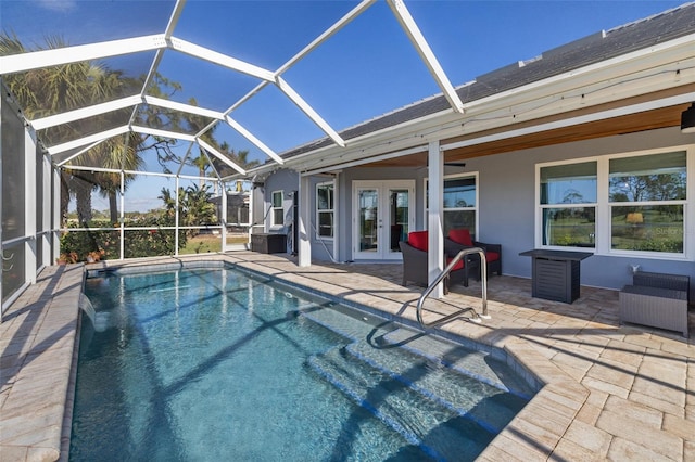 view of swimming pool with glass enclosure, ceiling fan, a patio, and french doors