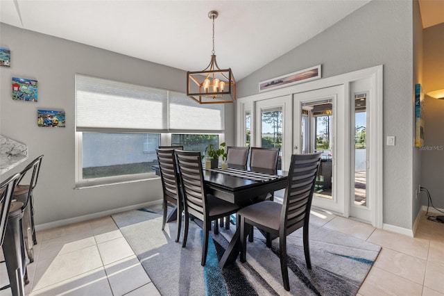 dining room with light tile patterned floors, lofted ceiling, a healthy amount of sunlight, and a notable chandelier