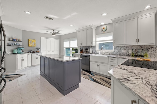 kitchen with ceiling fan, sink, a kitchen island, dishwashing machine, and white cabinets