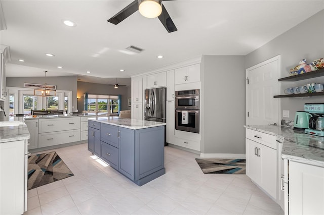 kitchen with kitchen peninsula, pendant lighting, white cabinets, ceiling fan with notable chandelier, and appliances with stainless steel finishes