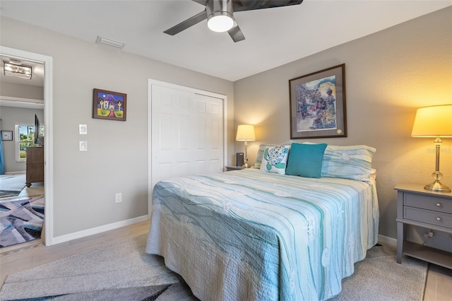 bedroom featuring light wood-type flooring, a closet, and ceiling fan