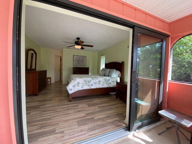 bedroom with ceiling fan, wood-type flooring, and a textured ceiling