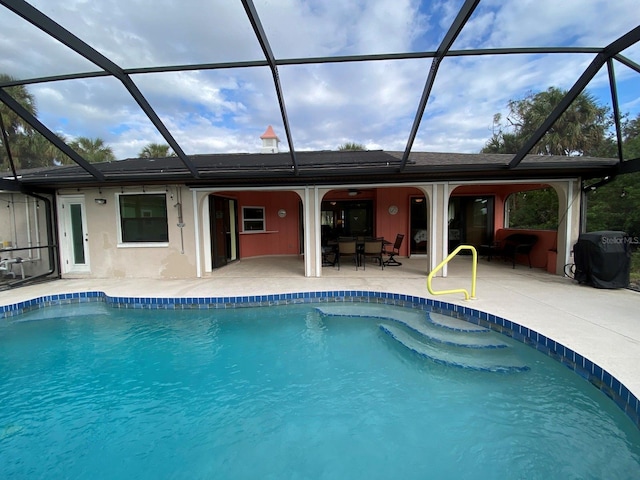 view of swimming pool featuring a patio and glass enclosure