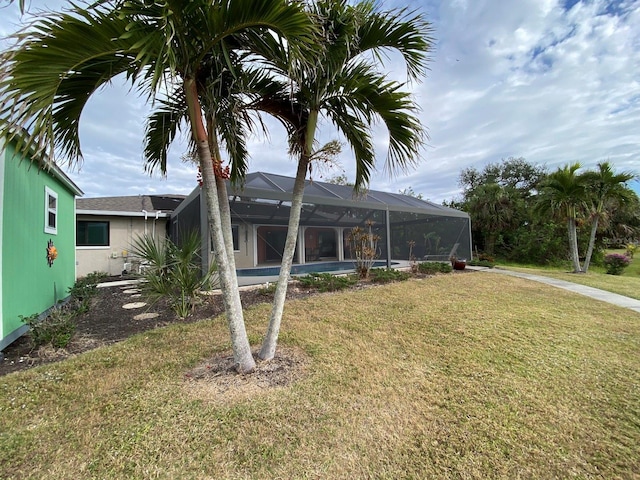 back of house with a lanai and a yard