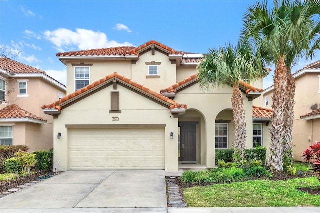 5240 Oakbourne Ave, Davenport, FL 33837 - mediterranean / spanish home with concrete driveway, a tiled roof, stucco siding, and a garage