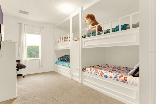 carpeted bedroom featuring a textured ceiling