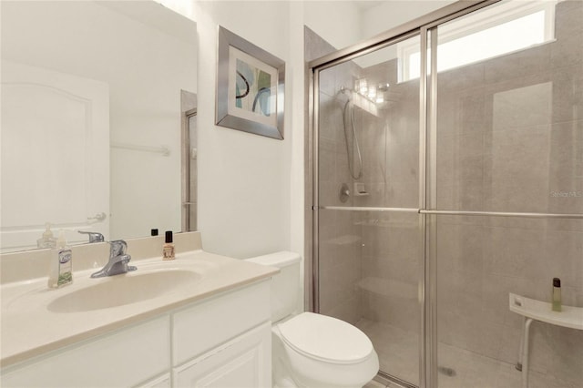 bathroom featuring vanity, toilet, and an enclosed shower