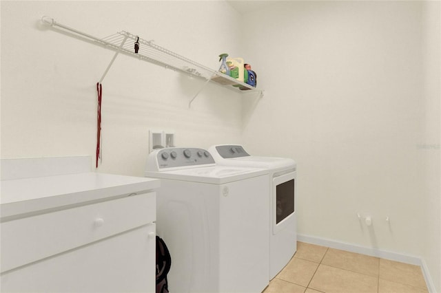 laundry room with washing machine and dryer and light tile patterned floors