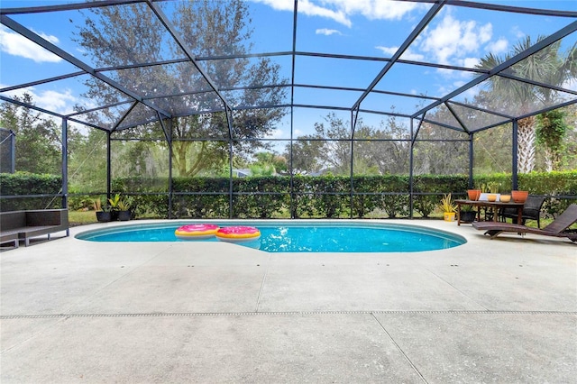 view of swimming pool featuring glass enclosure and a patio area