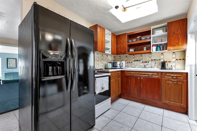 kitchen featuring light tile patterned floors, white electric range, a skylight, tasteful backsplash, and black fridge