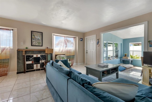 tiled living room featuring plenty of natural light and a fireplace