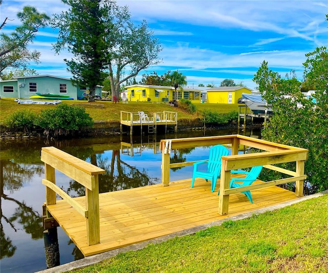 exterior space featuring a water view, a boat dock, and a lawn