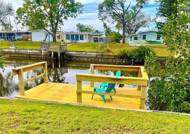 dock area featuring a water view and a lawn