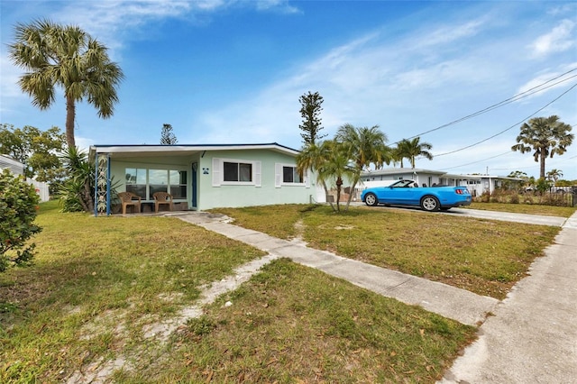 ranch-style home featuring a carport and a front lawn