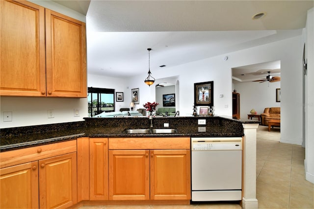 kitchen featuring white dishwasher, sink, ceiling fan, dark stone countertops, and kitchen peninsula