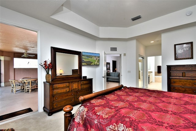 bedroom with ensuite bathroom, carpet floors, and ceiling fan