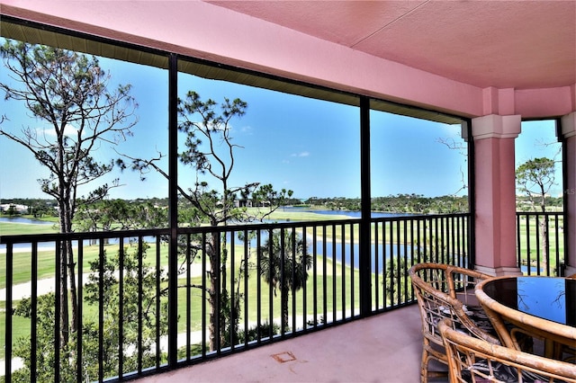 sunroom featuring a water view