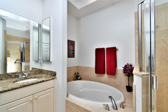 bathroom featuring shower with separate bathtub and vanity