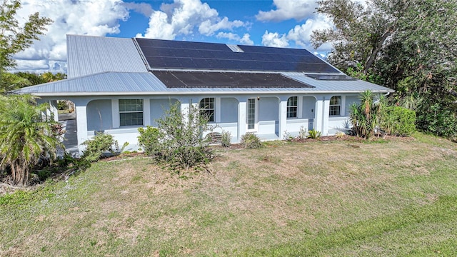 view of front of property with a front lawn and solar panels