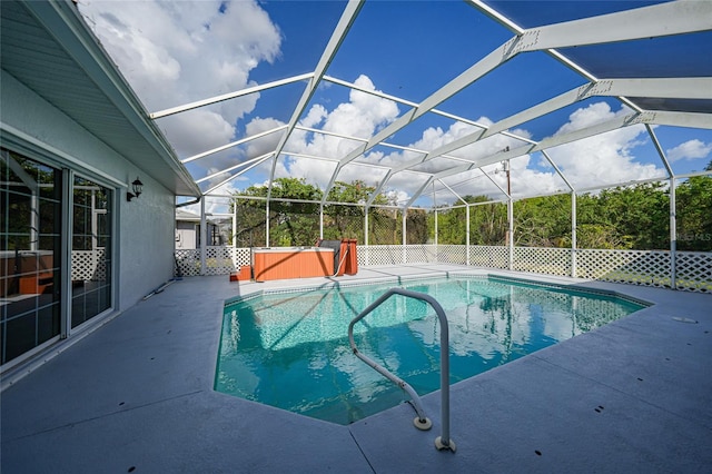 view of swimming pool with a lanai, a patio area, and a hot tub