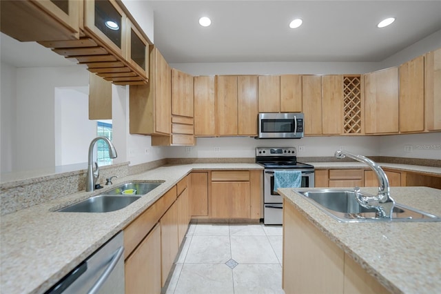 kitchen featuring appliances with stainless steel finishes, sink, light tile patterned floors, and light brown cabinetry