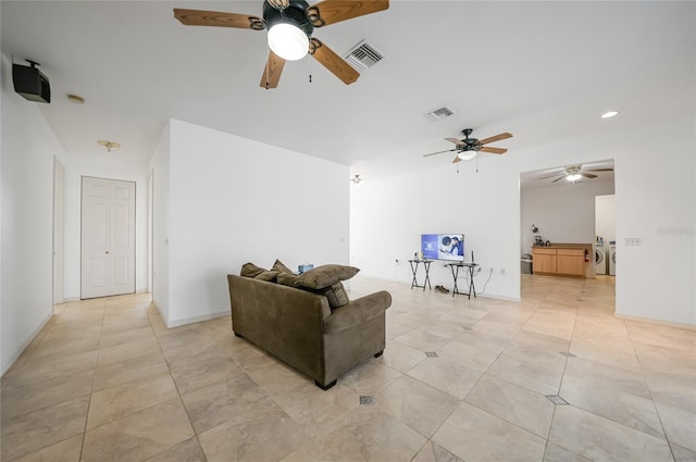 tiled living room featuring separate washer and dryer