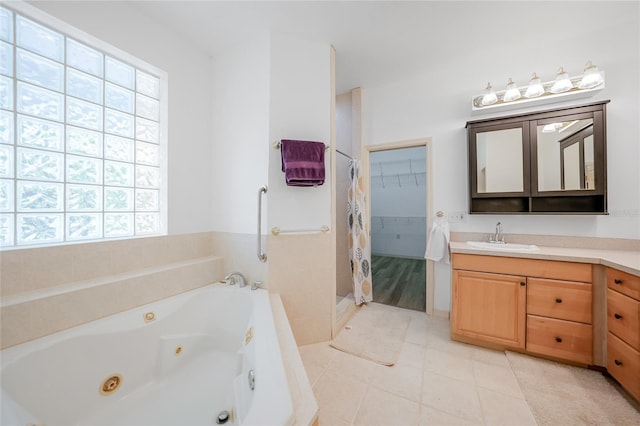 bathroom with tile patterned floors, plenty of natural light, shower with separate bathtub, and vanity