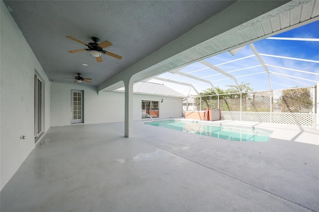 view of swimming pool with a patio area, ceiling fan, and glass enclosure